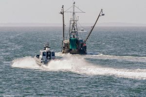 U.S. patrol boat passing a commercial fishing boat