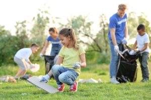 Adults and children clean up litter