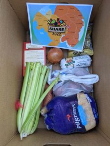 Box with celery, turkey, stuffing, and other food items to make a Thanksgiving meal