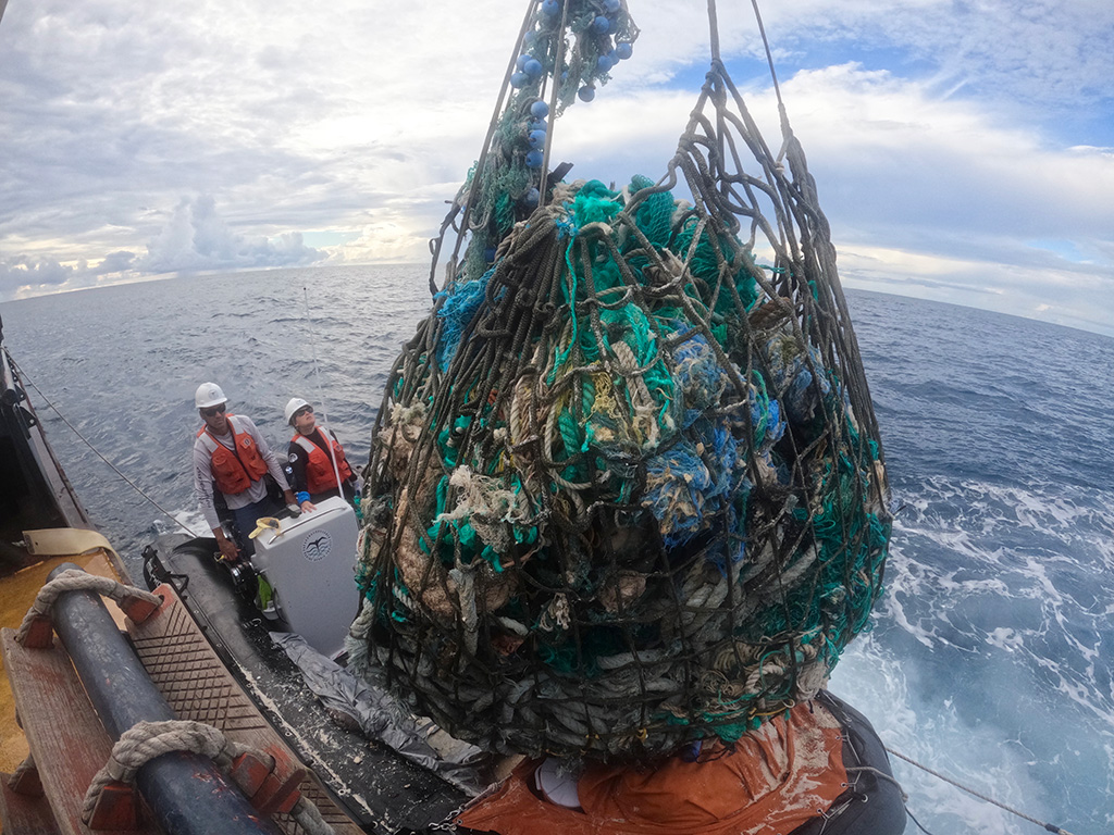 transferring derelict fishing nets from a Zodiac boat to the main vessel