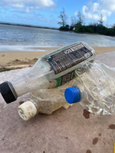 three plastic bottles laying on the beach